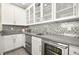 Convenient wet bar with glass cabinets, beverage fridge, and stylish backsplash at 12217 Tempestad Ave, Las Vegas, NV 89138