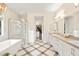 Primary bathroom featuring a double vanity, soaking tub, walk-in shower, and decorative tile floor at 12217 Tempestad Ave, Las Vegas, NV 89138