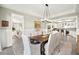 Elegant dining room with a modern chandelier, stylish seating, and an open view into the kitchen and bar area at 12217 Tempestad Ave, Las Vegas, NV 89138