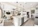 Spacious kitchen featuring a large island, farmhouse sink, stainless steel appliances, and an open view of the living area at 12217 Tempestad Ave, Las Vegas, NV 89138