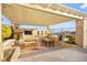 Covered outdoor kitchen with built-in grill and dining area perfect for entertaining guests in style at 12217 Tempestad Ave, Las Vegas, NV 89138