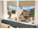 View through a window to an outdoor living space with seating, dining, and outdoor kitchen at 12217 Tempestad Ave, Las Vegas, NV 89138