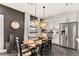 Dining area with dark accent wall features modern chandelier lighting and stainless steel refrigerator at 12648 Heritage Bend Dr, Las Vegas, NV 89138