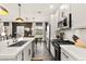 Bright kitchen view shows white cabinets, countertops, stainless appliances, dark accent wall and dining area at 12648 Heritage Bend Dr, Las Vegas, NV 89138