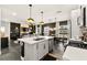 Spacious kitchen boasts quartz island countertop, white cabinets, stainless appliances and adjoining dining and living area at 12648 Heritage Bend Dr, Las Vegas, NV 89138