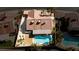 Aerial view featuring a kidney-shaped pool, covered patio, desert landscaping, and nearby neighboring pools at 1528 Tonada Way, Las Vegas, NV 89117