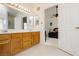 Bathroom with double sinks and vanity with wood cabinets, plus a bedroom view at 1528 Tonada Way, Las Vegas, NV 89117