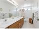 Well-lit bathroom with a large vanity mirror, double sinks, and tub shower combo at 1528 Tonada Way, Las Vegas, NV 89117