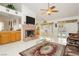 Open living room featuring a fireplace, wet bar, ceiling fan, and sliding glass doors to the pool at 1528 Tonada Way, Las Vegas, NV 89117