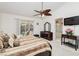 Cozy main bedroom with neutral decor, ceiling fan, and access to ensuite bathroom and backyard at 1528 Tonada Way, Las Vegas, NV 89117