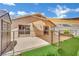 The backyard features a concrete patio, artificial grass, a shade sail, and an outbuilding at 1676 Divinity St, Las Vegas, NV 89142