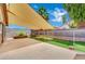 A spacious backyard featuring a concrete patio, artificial grass, a shade sail, and a chain-link fence at 1676 Divinity St, Las Vegas, NV 89142