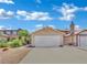 Charming home with a two-car garage and driveway, set against a bright, cloudy sky at 1676 Divinity St, Las Vegas, NV 89142