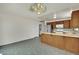 Open concept kitchen with adjacent laundry room, wood cabinetry, and tiled floors at 1676 Divinity St, Las Vegas, NV 89142