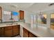Bright kitchen with wood cabinetry, stainless sink, tile floors, and view to the backyard at 1676 Divinity St, Las Vegas, NV 89142