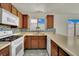 Well-lit kitchen features wood cabinets, stainless steel sink, mosaic backsplash, and bright windows at 1676 Divinity St, Las Vegas, NV 89142