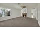 Spacious living room featuring plush carpet, a fireplace, and natural light from a large window at 1676 Divinity St, Las Vegas, NV 89142