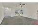 Bright living room featuring neutral carpet, a ceiling fan, and large windows at 1676 Divinity St, Las Vegas, NV 89142