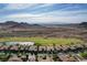 A panoramic aerial shot displays a neighborhood with homes and landscaping next to a pond, with a desert backdrop at 19 Contrada Fiore Dr, Henderson, NV 89011