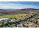 High-angle view showcasing homes with desert landscaping next to a pond, with mountain range in the background at 19 Contrada Fiore Dr, Henderson, NV 89011