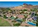 An aerial view of backyard pools, patios, and desert landscaping in a suburban neighborhood against a backdrop of mountains at 19 Contrada Fiore Dr, Henderson, NV 89011