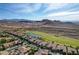 Scenic aerial view of a luxury neighborhood, green golf course, and mountain views on a clear sunny day at 19 Contrada Fiore Dr, Henderson, NV 89011