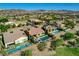 An elevated view of several homes with pools, landscaping, and mountains in the distance in a suburban neighborhood at 19 Contrada Fiore Dr, Henderson, NV 89011
