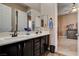 Bathroom featuring double sinks, white marble countertops, dark cabinets, and tile flooring at 19 Contrada Fiore Dr, Henderson, NV 89011
