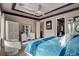 Well-lit bedroom featuring a tray ceiling, neutral walls and decor, with furniture and ensuite access at 19 Contrada Fiore Dr, Henderson, NV 89011