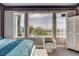 Bright bedroom features three large windows with exterior views, an accent chair, and lovely decor at 19 Contrada Fiore Dr, Henderson, NV 89011