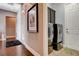 Hallway featuring a stacked washer and dryer, artwork, and wood-look flooring at 19 Contrada Fiore Dr, Henderson, NV 89011