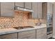 Close up on the kitchen with stainless steel appliances, modern cabinetry and mosaic backsplash at 19 Contrada Fiore Dr, Henderson, NV 89011