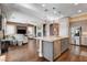 Open-concept kitchen with island flowing into a comfortable living area and fireplace at 19 Contrada Fiore Dr, Henderson, NV 89011