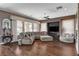 Spacious living room with wood floors, large windows, comfortable seating, and a ceiling fan at 19 Contrada Fiore Dr, Henderson, NV 89011