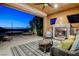 Relaxing covered patio featuring a stone fireplace and comfortable wicker furniture at 19 Contrada Fiore Dr, Henderson, NV 89011