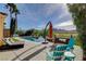 Backyard pool featuring patio seating, lounge chairs, a sun umbrella, and a picturesque mountain view at 19 Contrada Fiore Dr, Henderson, NV 89011