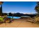 Inviting pool and spa with lounge chairs and mountain views at twilight at 19 Contrada Fiore Dr, Henderson, NV 89011
