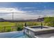 Infinity pool overlooking the serene golf course with blue skies and mountain views at 19 Contrada Fiore Dr, Henderson, NV 89011