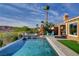Beautiful backyard pool with lush landscaping, a spa, patio seating, and mountain views at 19 Contrada Fiore Dr, Henderson, NV 89011