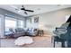 Well-lit living room featuring large windows, a comfortable gray couch, and a classic grand piano at 2090 Morro Vista Dr, Las Vegas, NV 89135