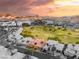 Stunning aerial view of a community with a golf course, mountains, and vibrant sunset backdrop at 21 Avenida Sorrento, Henderson, NV 89011