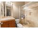 Bright bathroom with a glass-enclosed shower, warm neutral tile and wood cabinetry at 21 Avenida Sorrento, Henderson, NV 89011