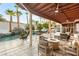 Inviting backyard featuring a covered patio with a fire pit, seating, and views of the waterfall pool at 2101 Diamond Bar Dr, Las Vegas, NV 89117