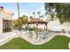 Beautiful backyard with a pergola, unique seating arrangements, synthetic grass, and desert landscaping at 2101 Diamond Bar Dr, Las Vegas, NV 89117
