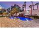 Backyard oasis featuring a custom pool, rock waterfall, lush landscaping, and a sun-drenched patio at 2101 Diamond Bar Dr, Las Vegas, NV 89117
