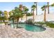 Beautiful backyard pool with a charming waterfall feature, surrounded by lush palm trees and stone accents at 2101 Diamond Bar Dr, Las Vegas, NV 89117