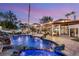 Gorgeous backyard with a custom pool featuring a rock waterfall, lighting, and a covered patio area at 2101 Diamond Bar Dr, Las Vegas, NV 89117
