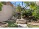 Multi-tiered landscaped backyard featuring decorative rock, trees, and lush greenery at 2164 Sawtooth Mountain Dr, Henderson, NV 89044