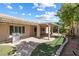 Backyard featuring covered patio, artificial grass, and lush landscaping at 2164 Sawtooth Mountain Dr, Henderson, NV 89044