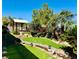Lush backyard featuring a tranquil pond, bridge and gazebo amidst verdant landscaping, blending nature's beauty with outdoor enjoyment at 2312 Indigo Island St, Henderson, NV 89044